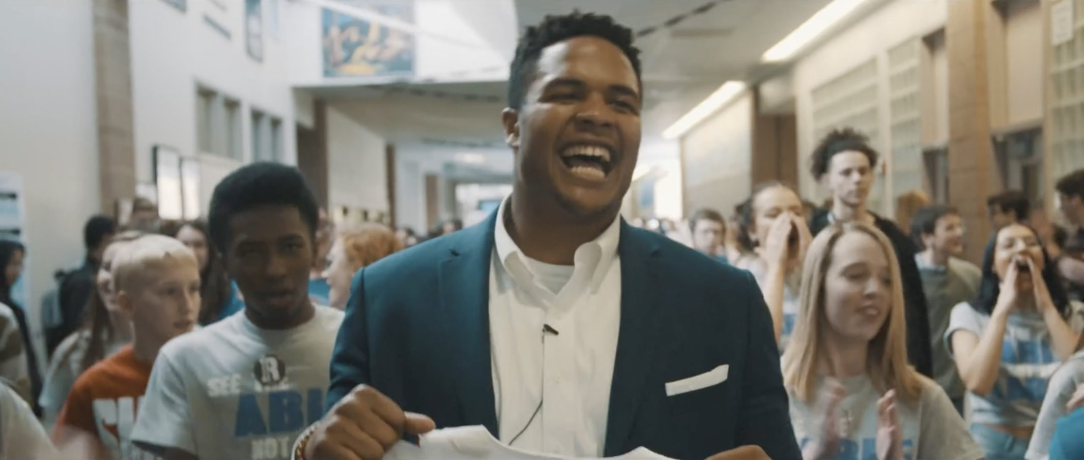 Eddie Yarbrough smiling as he walks down the hallway of his high school.