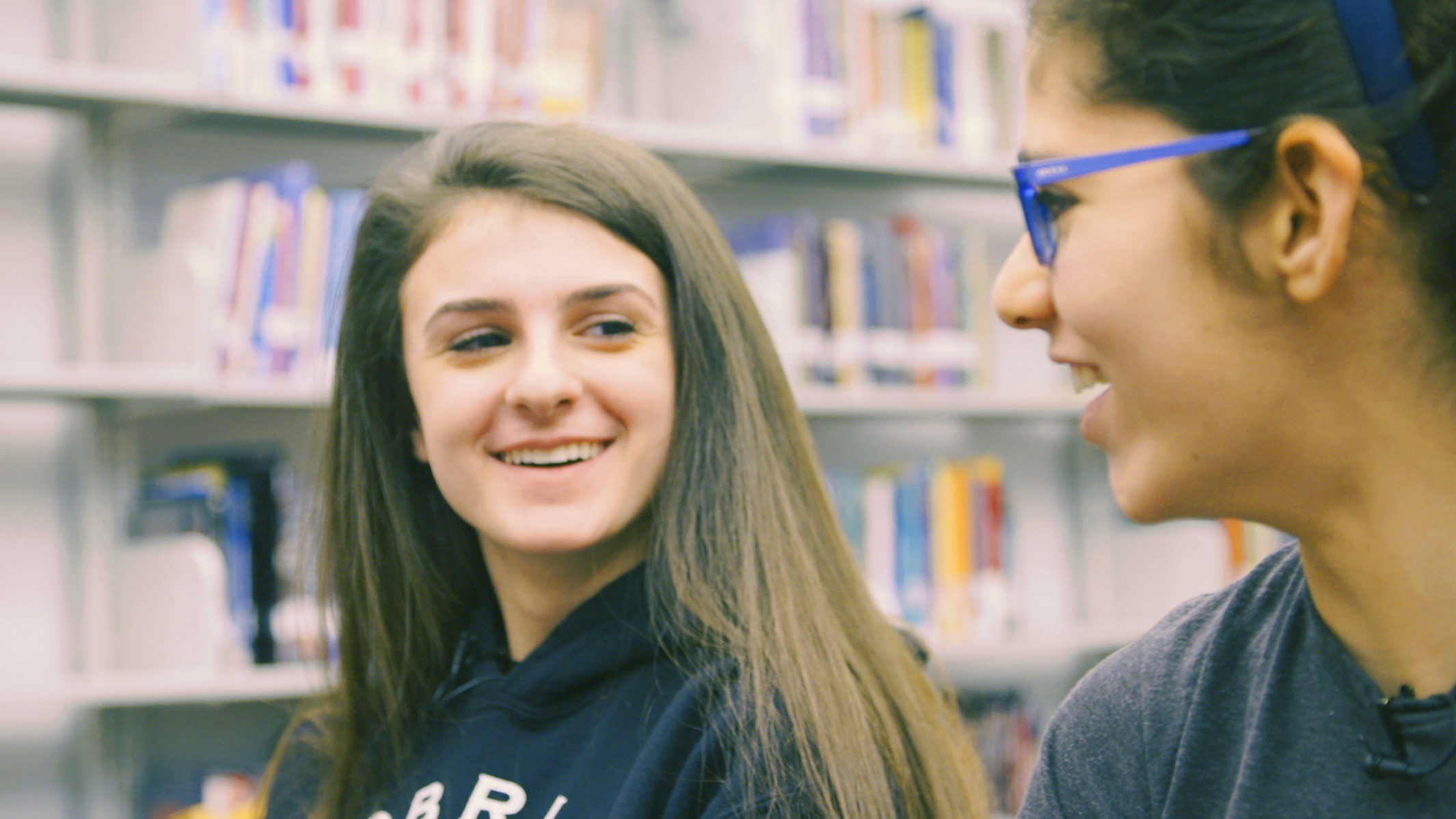 Students from Old Bridge Paige and Bella looking at each other smiling.