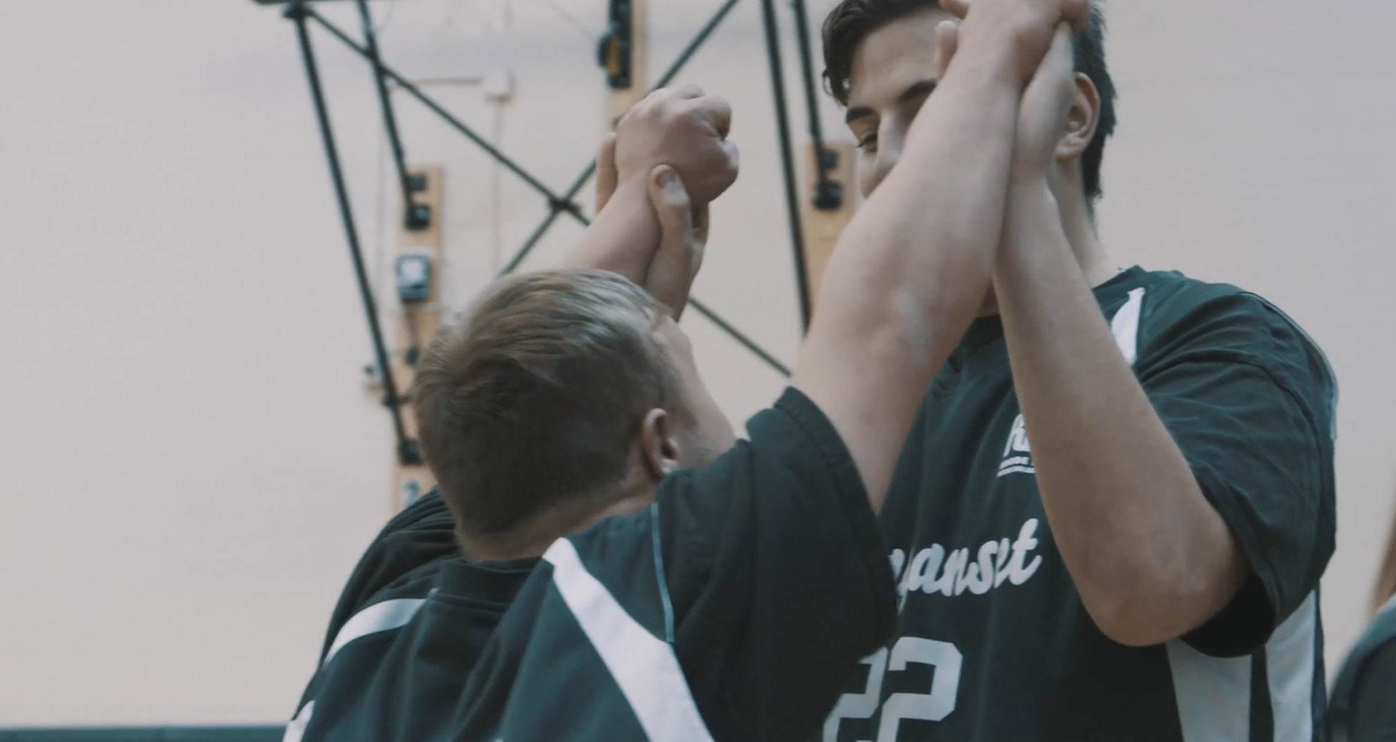 Two students from Ponaganset High School congratualting each other during a Unified Sports game.