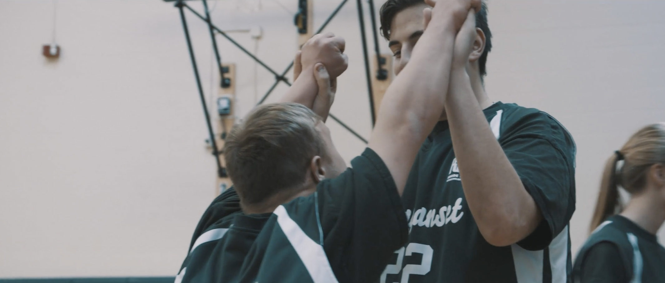 Two students from Ponaganset High School congratualting each other during a Unified Sports game.