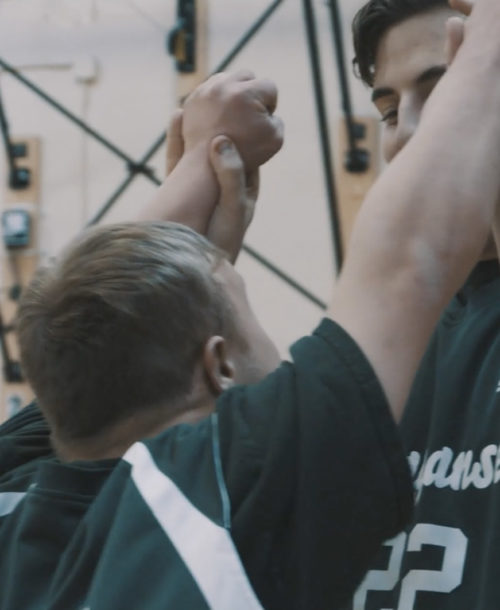 Two students from Ponaganset High School congratualting each other during a Unified Sports game.