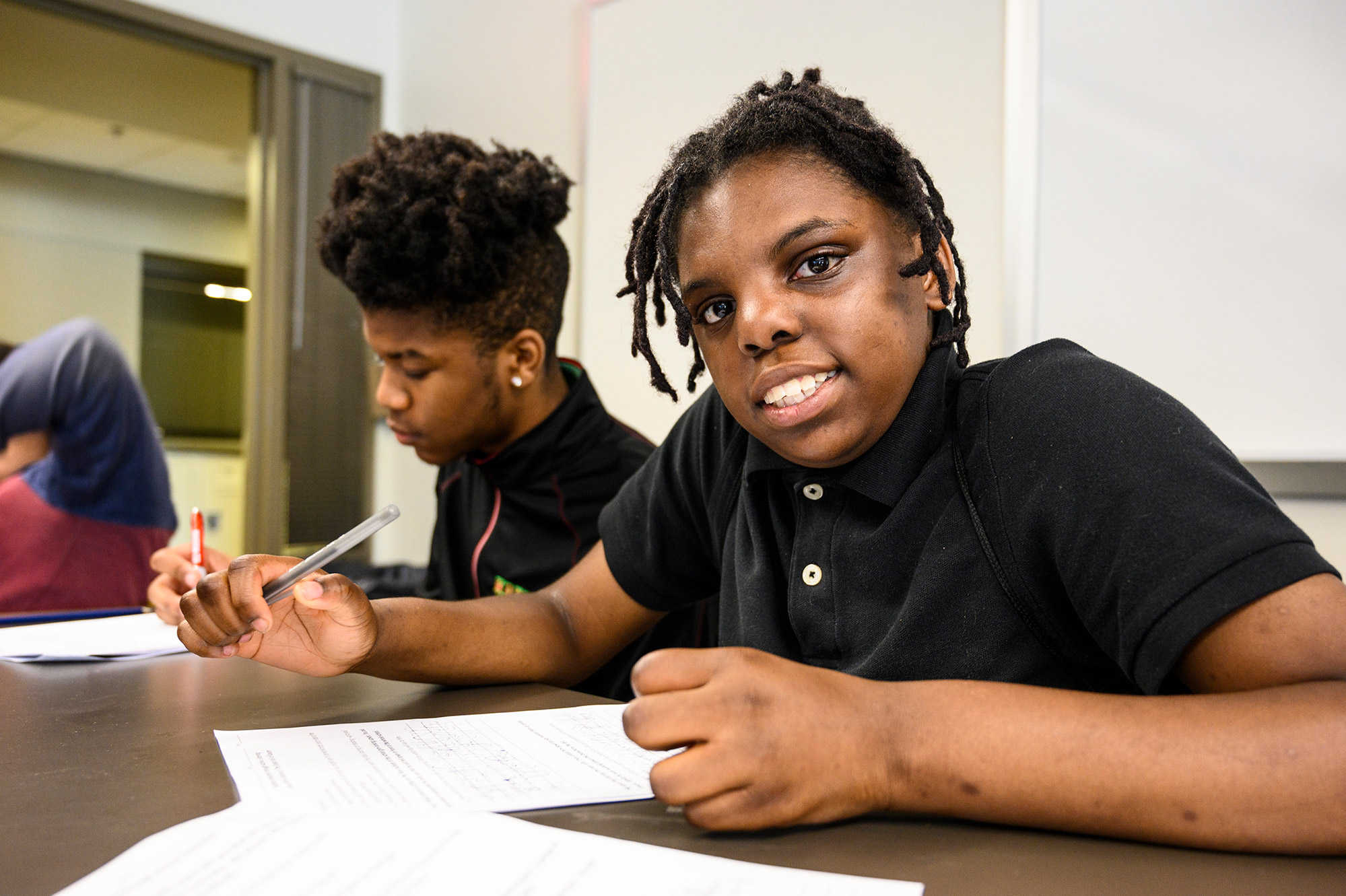 Student looking up at the camera while working on an assignment.