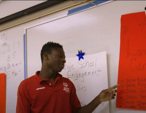A youth leader points at a poster he's been working on.