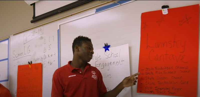 A youth leader points at a poster he's been working on.