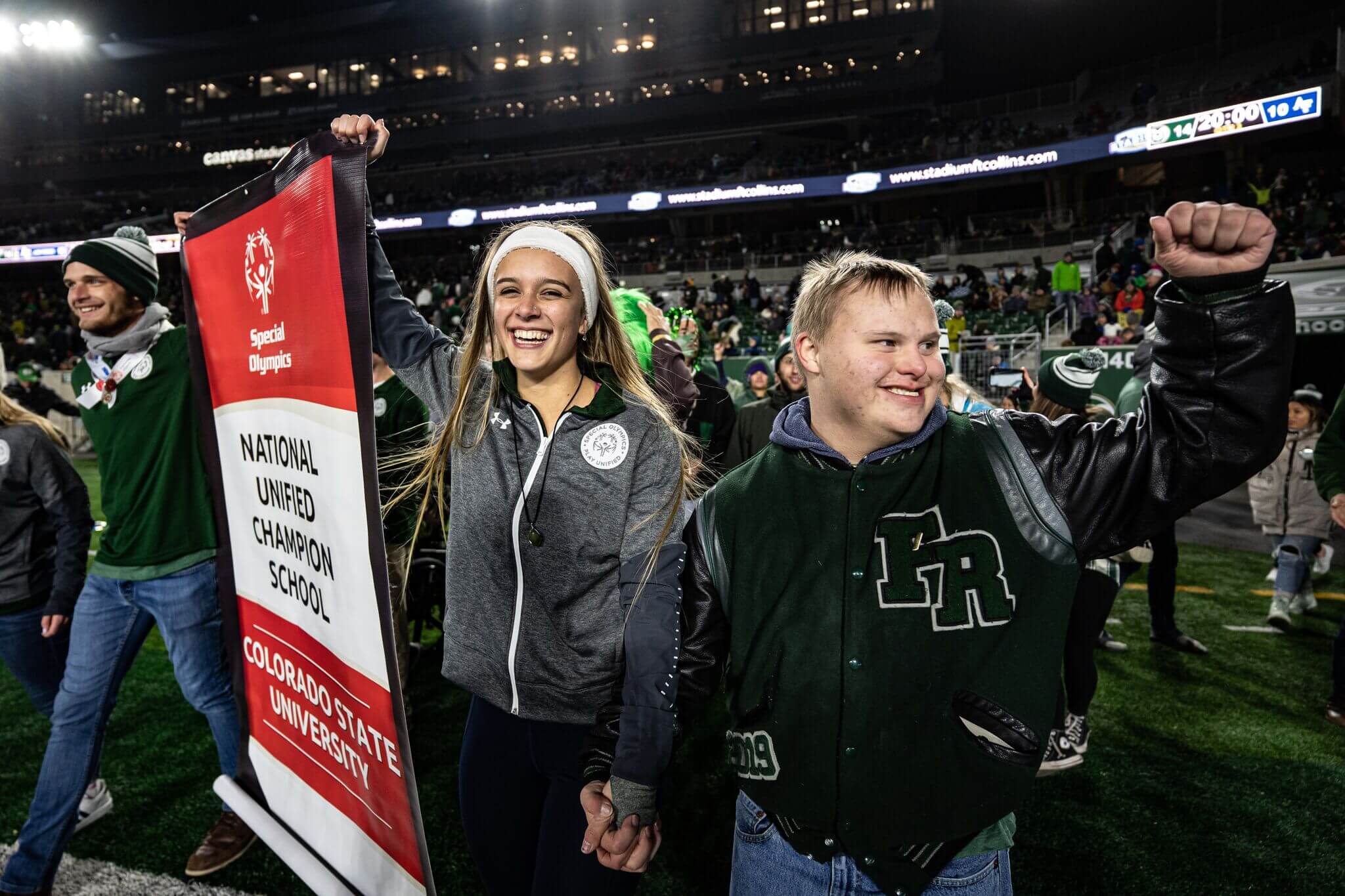 Two members of an SO College waiving while holding their National Banner.