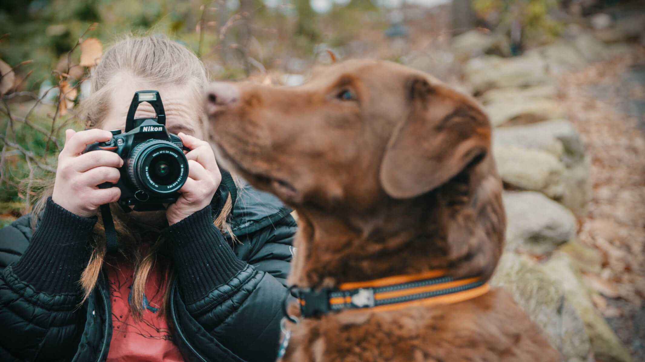 Kate takes a photograph of her dog, a chocolate labrador.