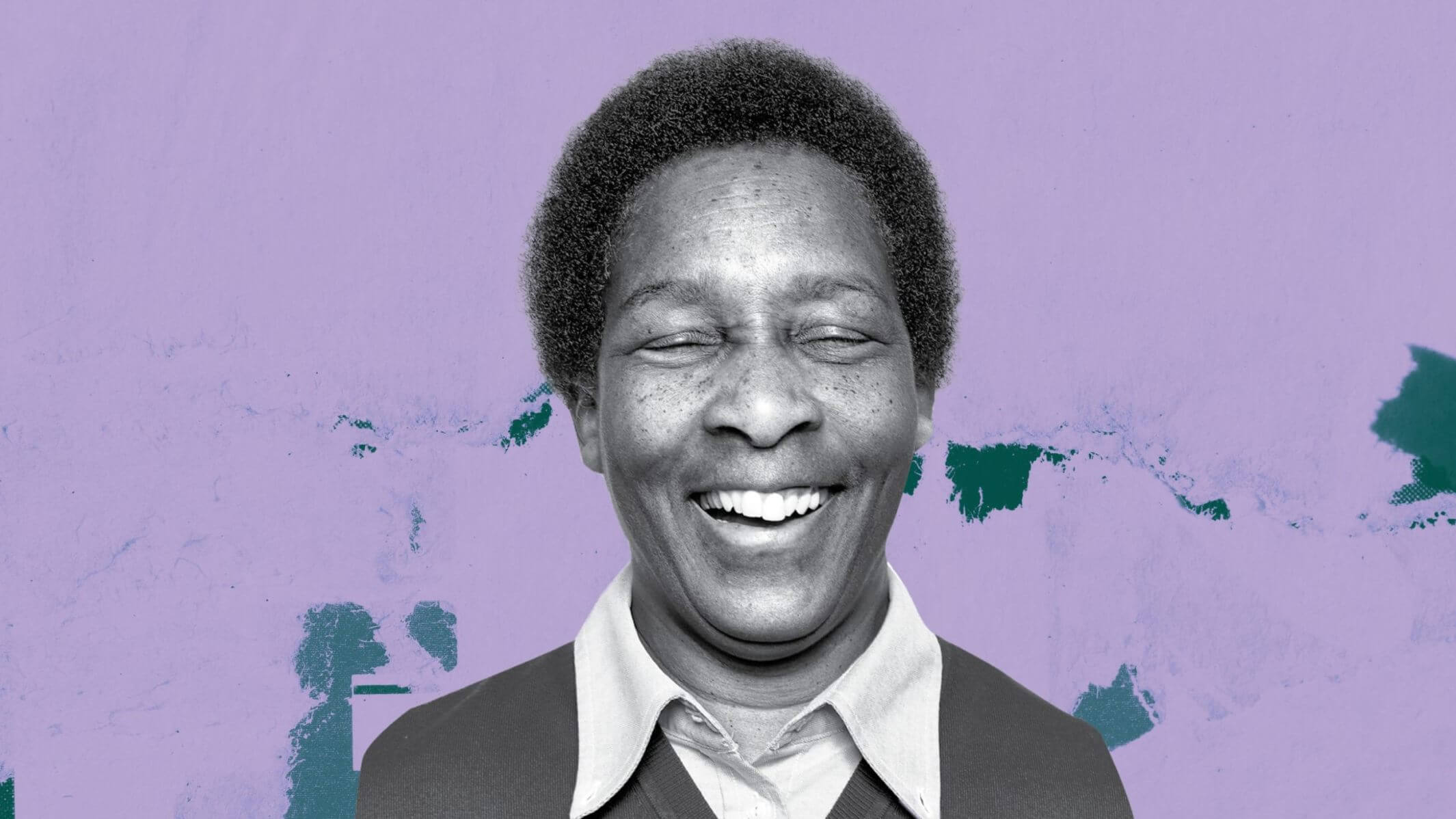 An Image of Loretta Claiborne smiling with her eyes closed. She is in black and white but there is a colorful background behind her.