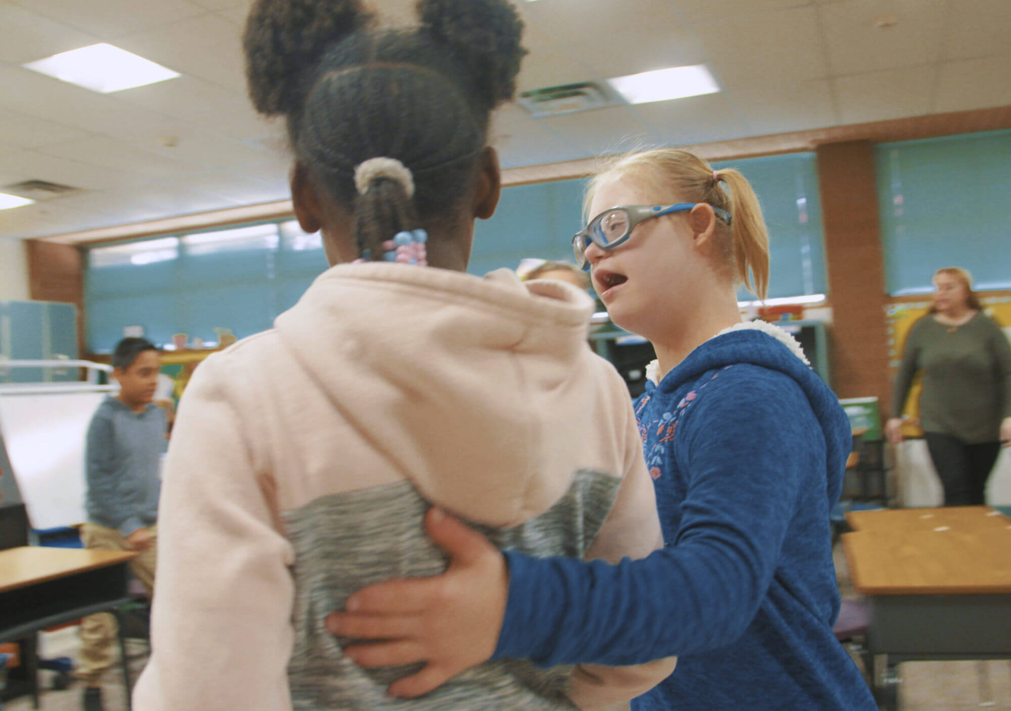 A student from Copper King Elementary puts her arm around another student.