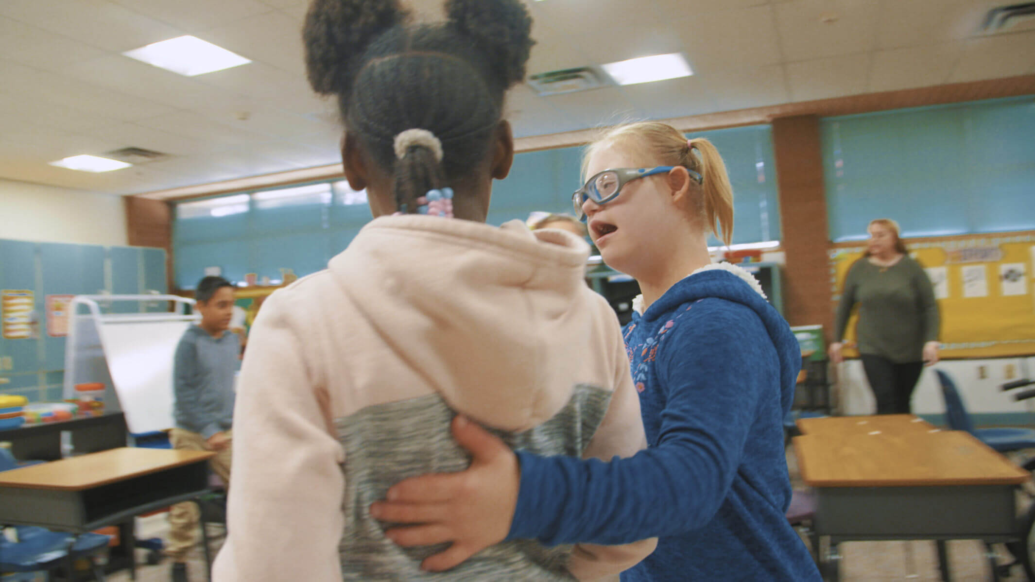 A student from Copper King Elementary puts her arm around another student.