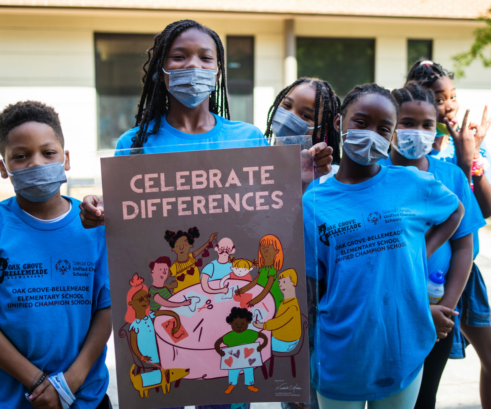 African American students wearing COVID masks posing with a poster that says 