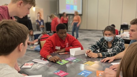 U.S. Youth Ambassadors and students from Detroit working on Inclusion Tiles around a table.